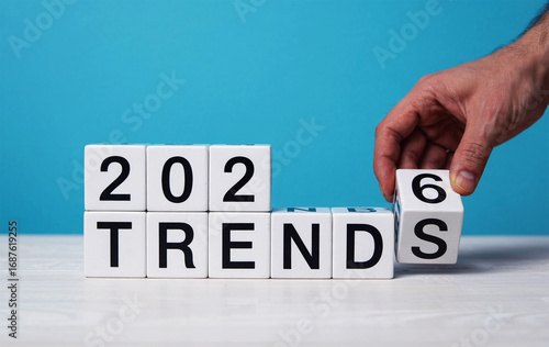 Hand adding number 6 to 2025 blocks spelling trends futuristic concept