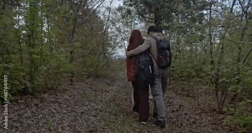 Wallpaper Mural A multicultural family with backpacks walks through a peaceful green forest. They enjoy nature and quality time together, highlighting connection, adventure, and the beauty of the outdoors. Torontodigital.ca