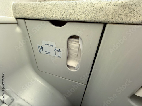 Photography Airplane lavatory waste disposal compartment with tissues and signage