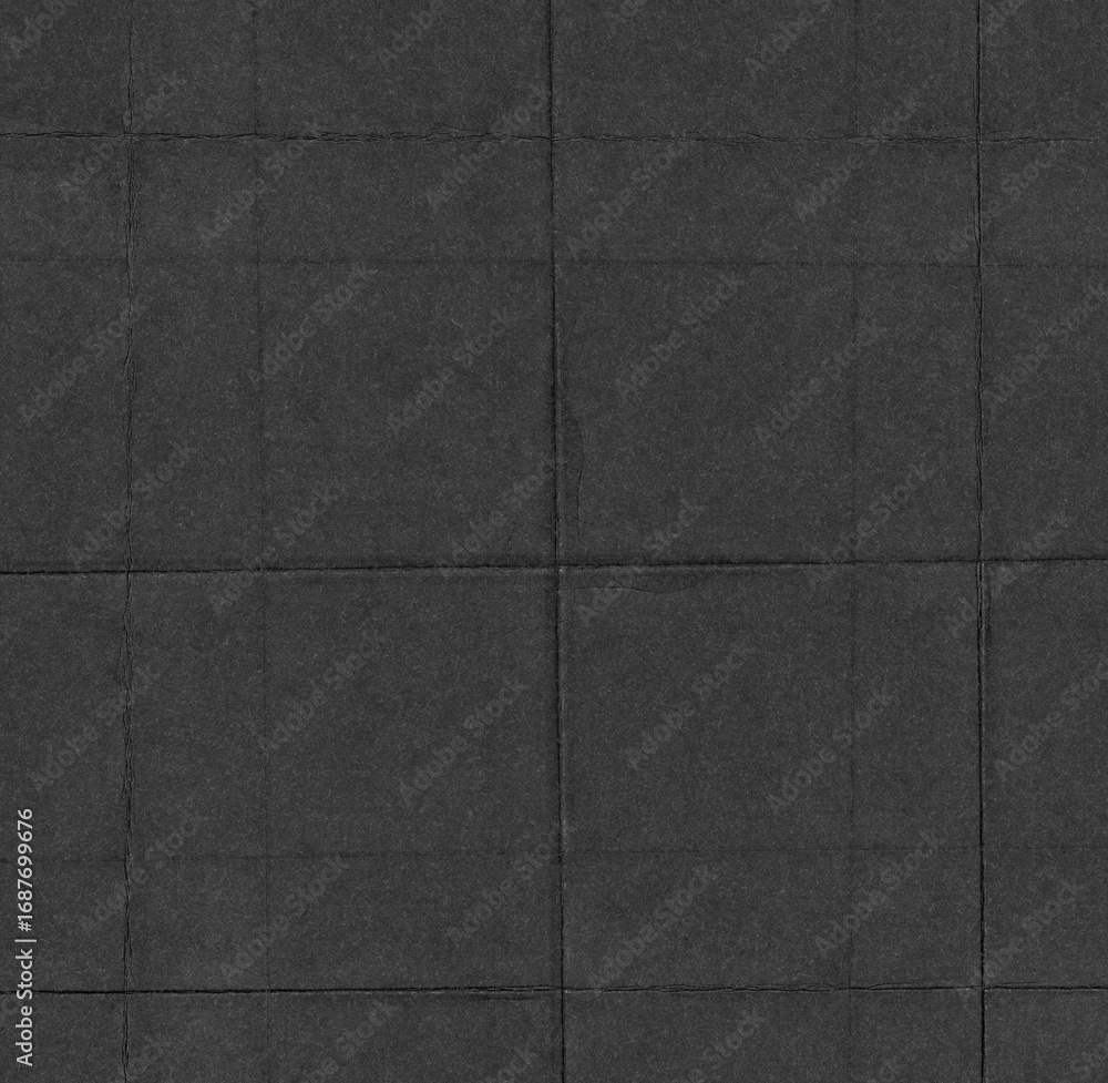 Fototapeta premium High-resolution black paper texture with visible creases and fold marks arranged in a grid pattern. The surface shows natural imperfections, giving it a worn, distressed, and tactile look.