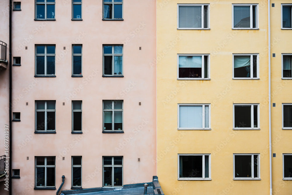 Fototapeta premium Facade of pastel pink and yellow apartment buildings.