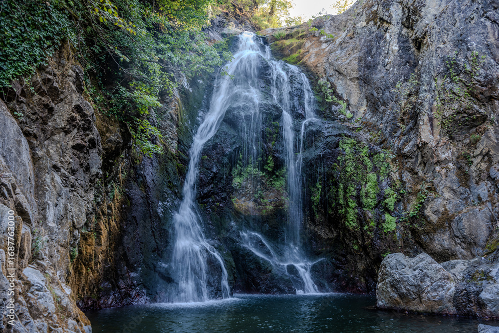 Fototapeta premium Waterfall flowing into rocky pool
