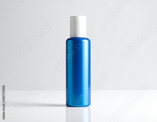 Blue cosmetic bottle standing tall with white cap on reflective surface