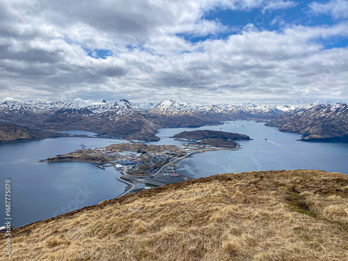 Panoramic aerial view of Unalaska Island with airport, port, and mountains, Alaska Remote Aleutian Island town of Unalaska with harbor and snowy peaks