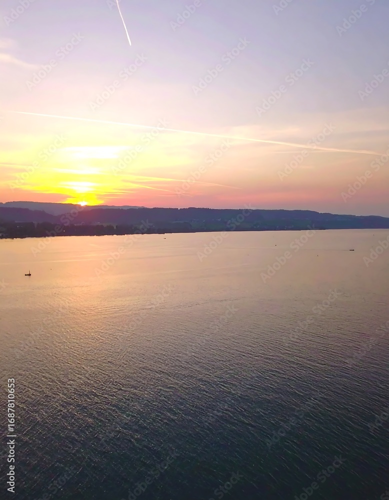 Obraz premium Panoramic sunset over calm water