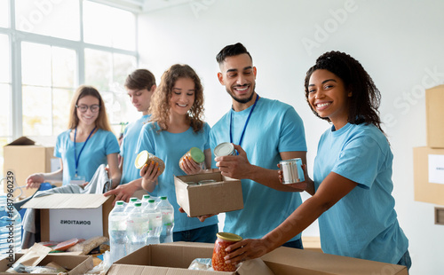 Cuadro en lienzo Diverse group of volunteers sorting donated food in boxes, working in community