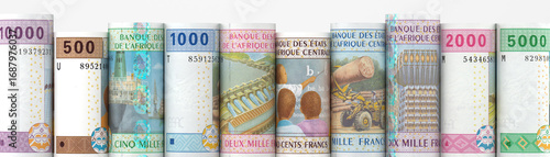 Rolled up central African CFA franc banknotes standing in a row on a white background