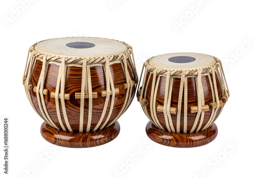 Two traditional Indian tabla drums, showcasing intricate wood grain patterns and beige straps, are displayed against a stark black backdrop.