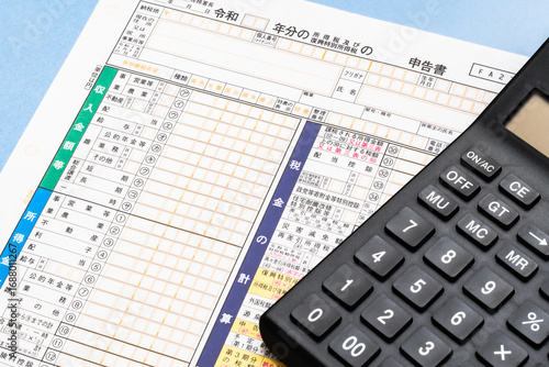 確定申告書と電卓を使った税金計算のイメージ