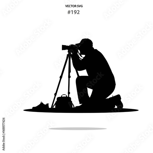 Dedicated photographer capturing stunning moments with professional camera equipment and tripod, kneeling in focused pursuit of the perfect shot.