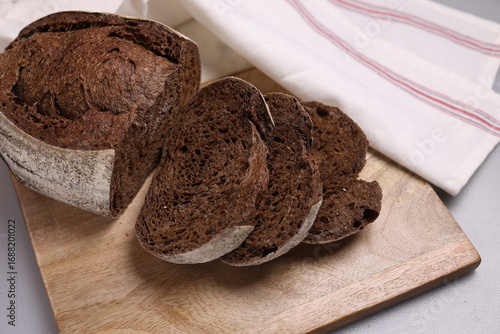 Fresh baked wholegrain bread on wood and marble board.