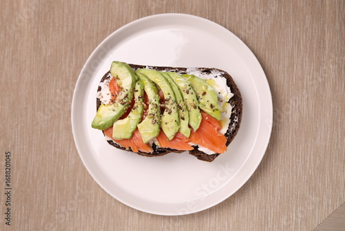 Delicious breakfast toast of wholegrain bread with smoked salmon cream cheese and avocado on it.
