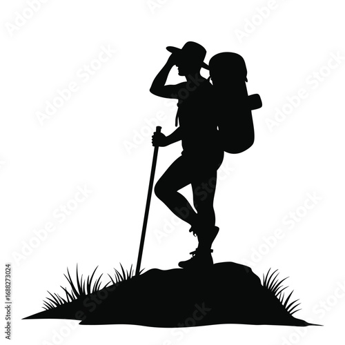 Silhouette of hiker with backpack and pole on rocky ground