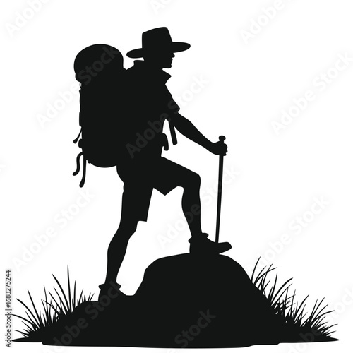 Silhouette of hiker with backpack and trekking pole on rock