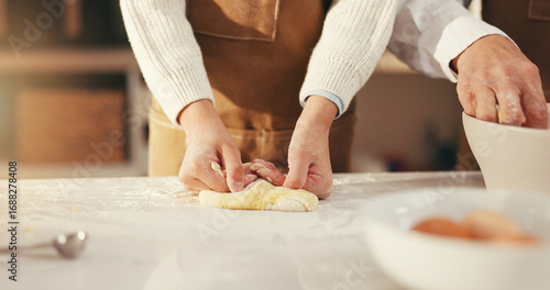 Hands, parent and kid with baking dough in home for cookies, learning and development. Family, people and girl kneading pastry in kitchen for scones recipe, culinary skills and dessert preparation