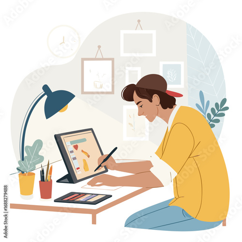 Focused young illustrator drawing on a digital tablet at his desk.