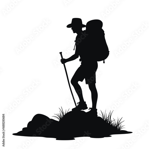 Silhouette of hiker with backpack and trekking pole on rocks