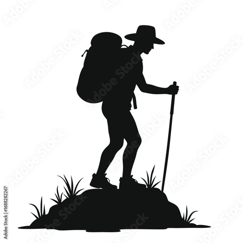 Silhouette of hiker with backpack and trekking pole on rocky terrain