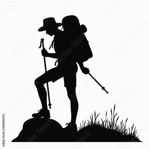 Silhouette of hiker with backpack and trekking poles on rock