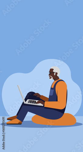 Smiling senior Black man in casual attire sitting on a cushion, actively engaged with his laptop, representing digital literacy and modern lifestyle.