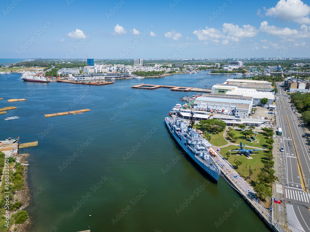 Fototapeta premium Tainan, Taiwan. Aerial view of Anping Harbor with the De Yang DDG-925 destroyer museum ship docked at the pier on a sunny summer day.