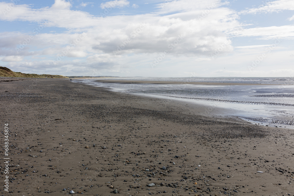 Obraz premium A summer seaside beach landscape during low tide in Northern Ireland.