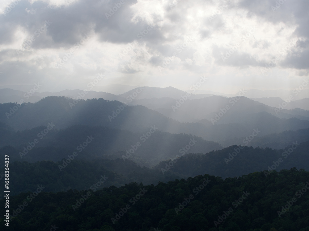 Obraz premium Sunset in the mountains with clouds and sunbeams, Thailand