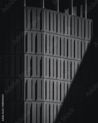 A modern stone building facade with clean geometric lines, minimalist design, and textured stone surfaces, highlighting contemporary architecture in natural light.