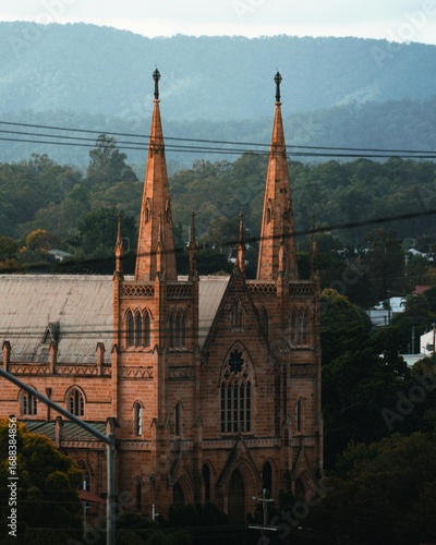 A historic brick St. Mary’s Catholic Church in Ipswich, Australia, featuring classic Gothic-style architecture, tall spires, and arched windows under a clear sky.