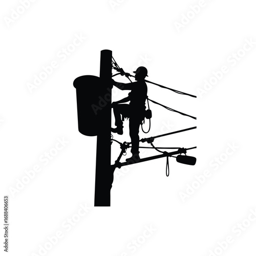 Silhouette of lineman working on power lines from bucket truck