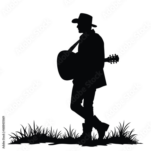 Silhouette of a man in a cowboy hat playing guitar in grass