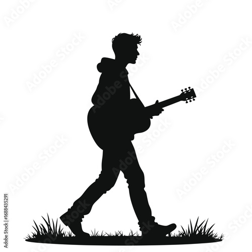 Silhouette of a man walking with an acoustic guitar