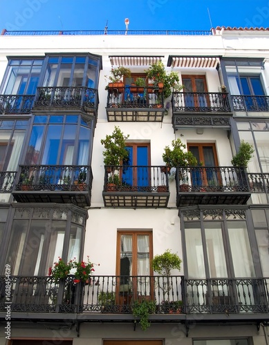 White building with balconies and plants