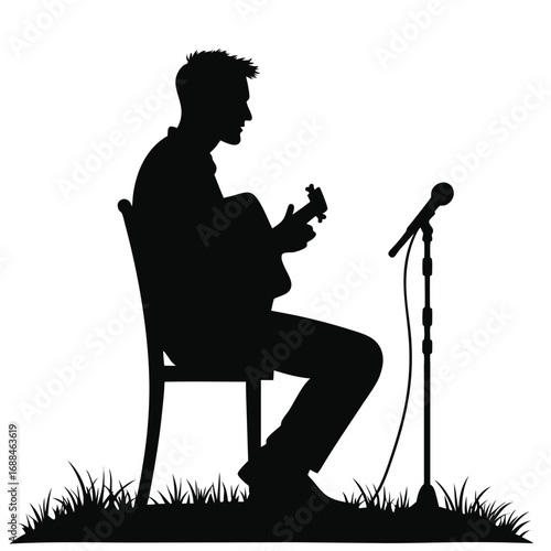 Silhouette man playing guitar and singing into microphone outdoors