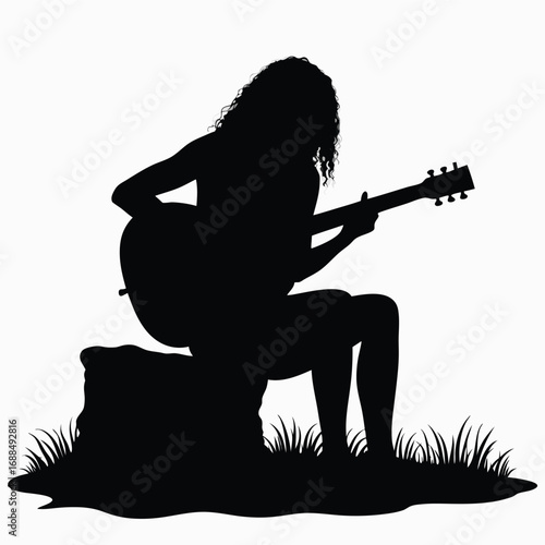 Silhouette of a person playing an acoustic guitar outdoors