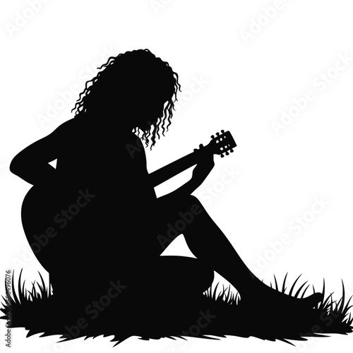Silhouette of a woman playing guitar in grass acoustic guitar