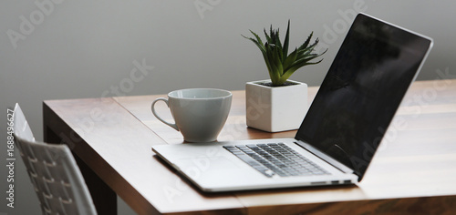 Office setup with a laptop on table along with peaceful environment- perfect for work- WFH- work from hone