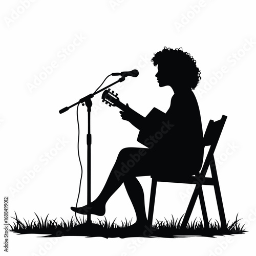 Silhouette of person playing guitar and singing into microphone outdoors