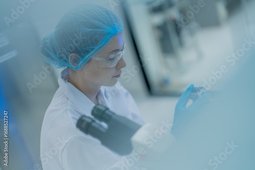 Scientist conducting research in a laboratory with advanced equipment during daylight hours