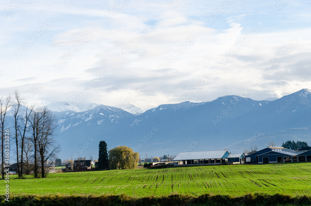 Obraz premium View of rural canada on Highway from Abbotsford to Hope, BC, Canada with mountains, valleys and farms in the background