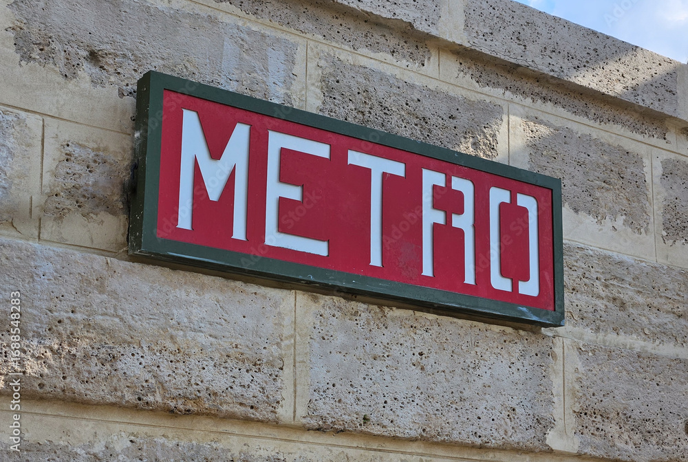 Obraz premium Red and white Metro sign indicating underground rapid transit system in Paris, France, promoting urban transportation and travel