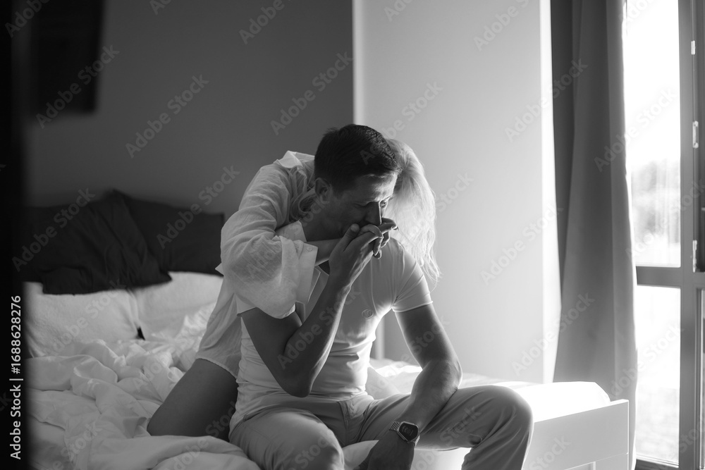 Naklejka premium Young couple kissing in an embrace. young couple a guy and a girl of Caucasian ethnicity in white T-shirts embrace kissing