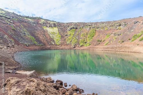 Descente au bord du lac turquoise du cratère du Kerið, avec ses parois rouges, dans le Cercle d'Or, en Islande
