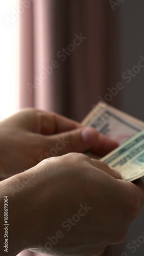 A lot of money in the hands of a man, 50 and 20 dollars.
A stack of saved money.
A man is happy with the money and profit.
A successful deal from sales.
Money, bills, cash, a lot