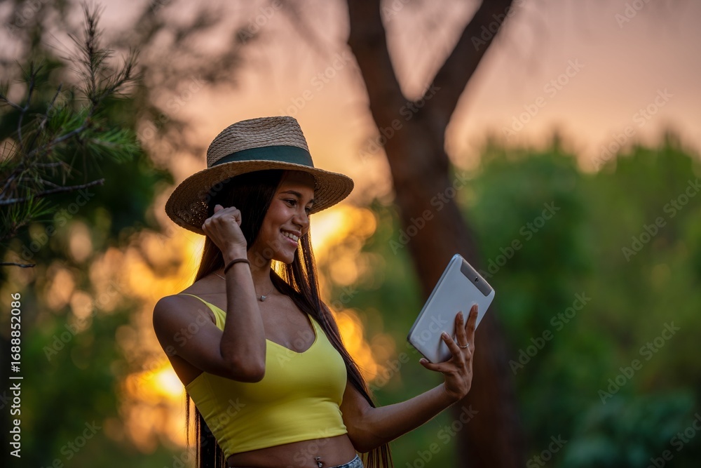 Fototapeta premium Woman Taking Selfie in Park at Sunset