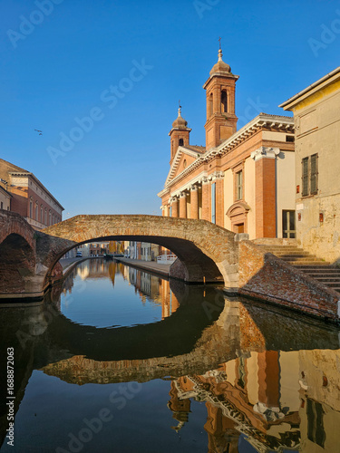 San Pietro Church and Brick Arch Bridge in Comacchio, Italy with Reflection in Canal