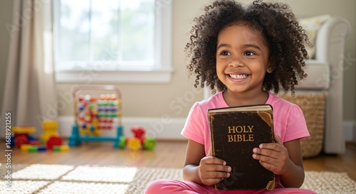 Close child holding a Holy Christian Bible symbolizing faith and spiritual learning