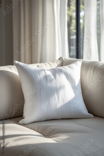Mockup of a white pillow lying on a sofa.