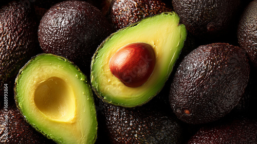 an overhead top-view angle of a massive pile of ripe avocados, appearing small due to the high perspective