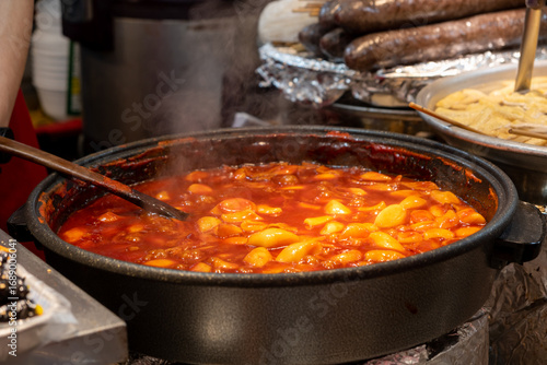 Tteokbokki, a soft chewy rice cakes in a spicy and sweet sauce made of gochujang in Gwangjang Market in Seoul, South Korea. It is a local market famous for traditional Korean street food.